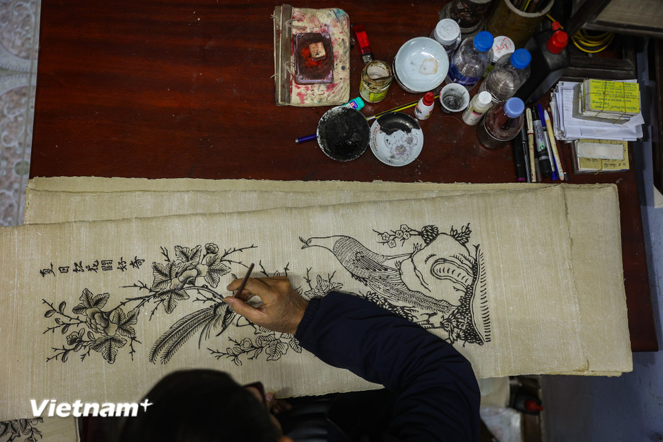 Ông Quả bảo rằng không chỉ đơn thuần là một bức tranh, mỗi bức tranh là một thông điệp, có khi là những lời răn rạy hay mong ước về những điều tốt lành trong cuộc sống. (Ảnh: Hoài Nam/Vietnam+)