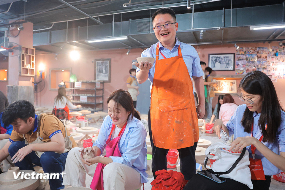 Đoàn viên Trung Quốc rất vui mừng và hào hứng khi tự tay nặn được sản phẩm gốm thủ công. (Ảnh: Hoài Nam/Vietnam+)