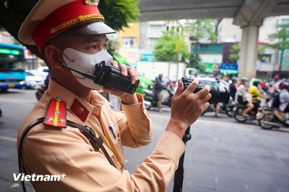 Trong quá trình ghi hình phát hiện người vi phạm, cán bộ Cảnh sát giao thông phụ trách sẽ dùng bộ đàm thông báo cho tổ công tác đồng thời gửi kèm hình ảnh người vi phạm để làm căn cứ xử lý. (Ảnh: Hoài Nam/Vietnam+)