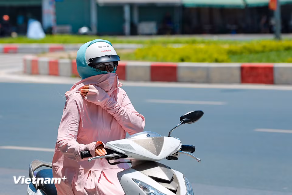 Cơ quan chức năng cũng khuyến cáo hạn chế đi ra ngoài đường, ngoài trời nóng khi không thật cần thiết. Nếu bắt buộc phải đi ra đường, ngoài trời nóng thì phải đội mũ, mặc quần áo, đeo kính, khẩu trang chống nóng. (Ảnh: Hoài Nam/Vietnam+)