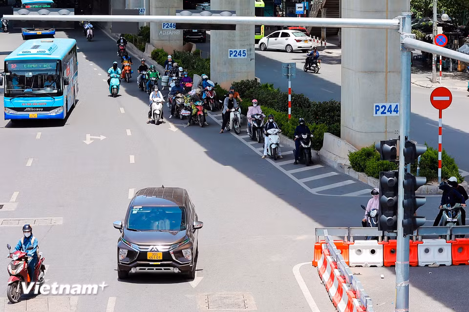 Nhiều phương tiện tham gia giao thông nép mình dưới bóng râm của đường sắt trên cao khi dừng chờ đèn đỏ. (Ảnh: Hoài Nam/Vietnam+)