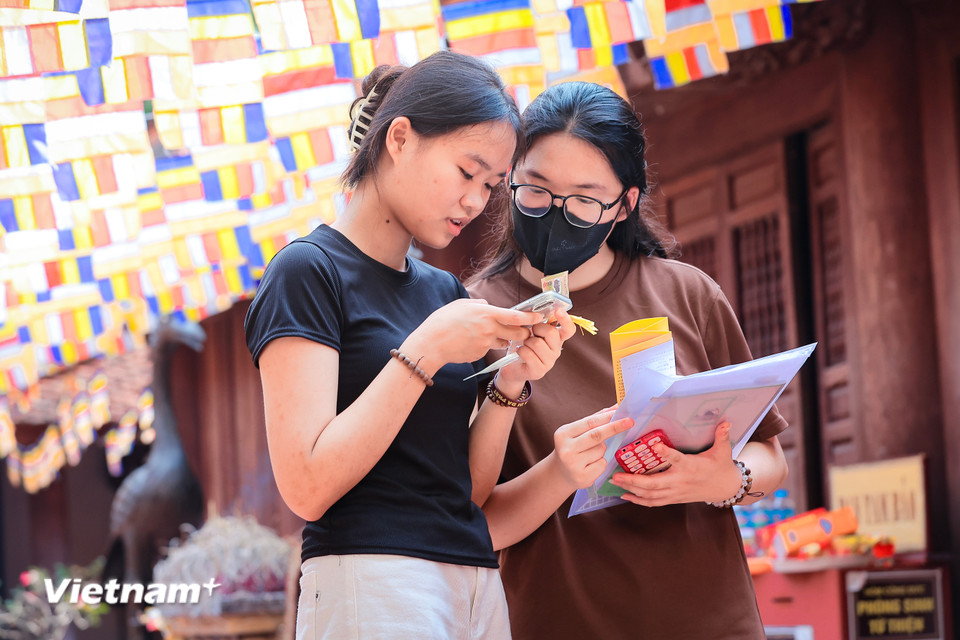 Em Trần Phương Thảo (Thanh Trì, Hà Nội) cùng bạn tới chùa Đậu để 'xin vía' đỗ đạt theo nguyện vọng của mình. (Ảnh: Hoài Nam/Vietnam+)