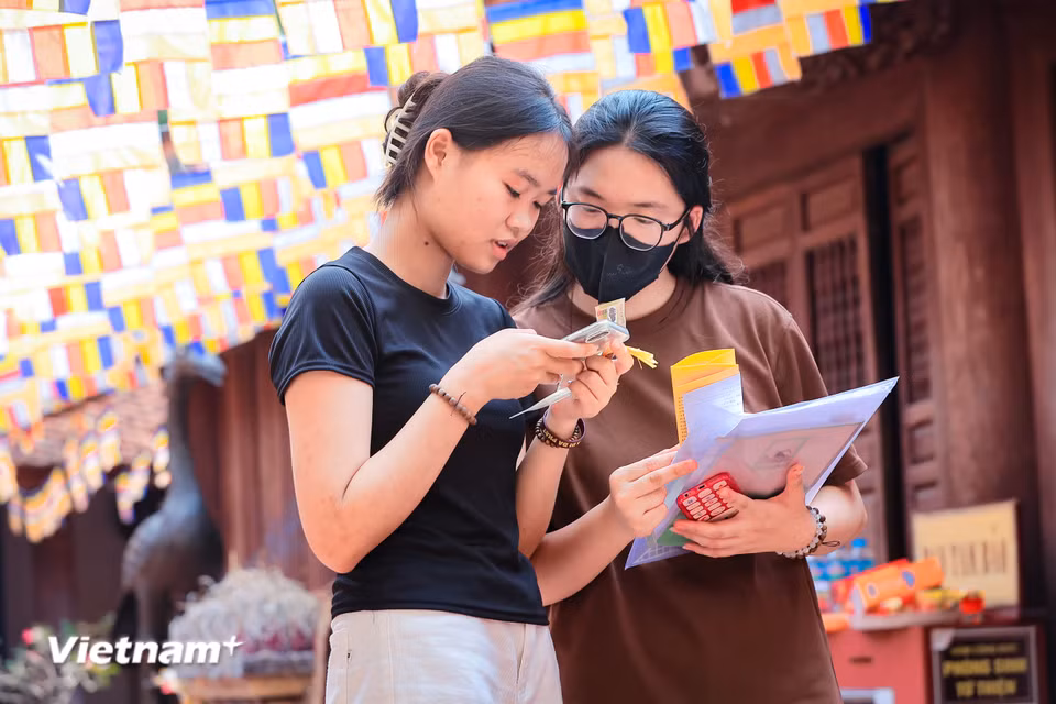 Em Trần Phương Thảo (Thanh Trì, Hà Nội) cùng bạn tới chùa Đậu để 'xin vía' đỗ đạt theo nguyện vọng của mình. (Ảnh: Hoài Nam/Vietnam+)