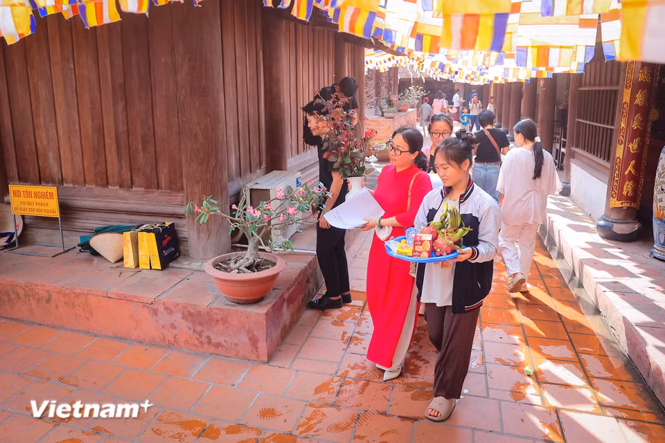 Trong mâm lễ hoa, quả, bánh trái còn có đồ dùng học tập như bút viết, thước kẻ. Sau khi lễ xong, các thí sinh sẽ dùng đồ dùng học tập ấy trong kỳ thi sắp tới. (Ảnh: Hoài Nam/Vietnam+)