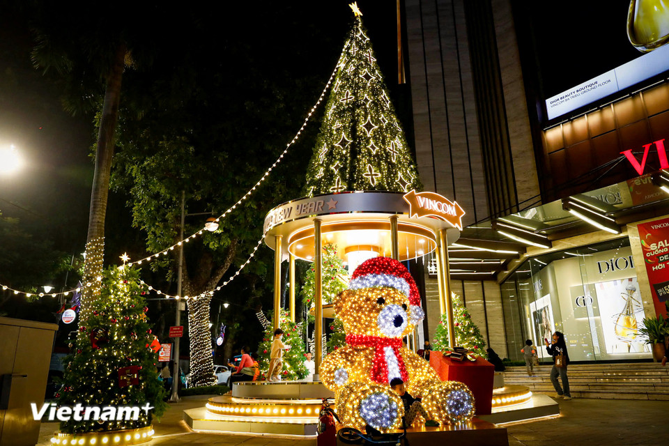 Tại các trung tâm thương mại, cây thông lớn được trang trí đèn rực rỡ trước sảnh cùng các vật trang trí bắt mắt khác để thu hút du khách.(Ảnh: Hoài Nam/Vietnam+)