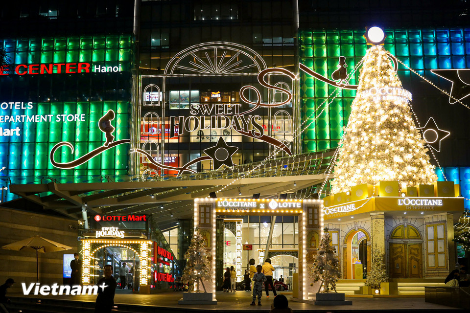 Trung tâm thương mại Lotte rực sáng ánh đèn vàng với cây thông khổng lồ. (Ảnh: Hoài Nam/Vietnam+)