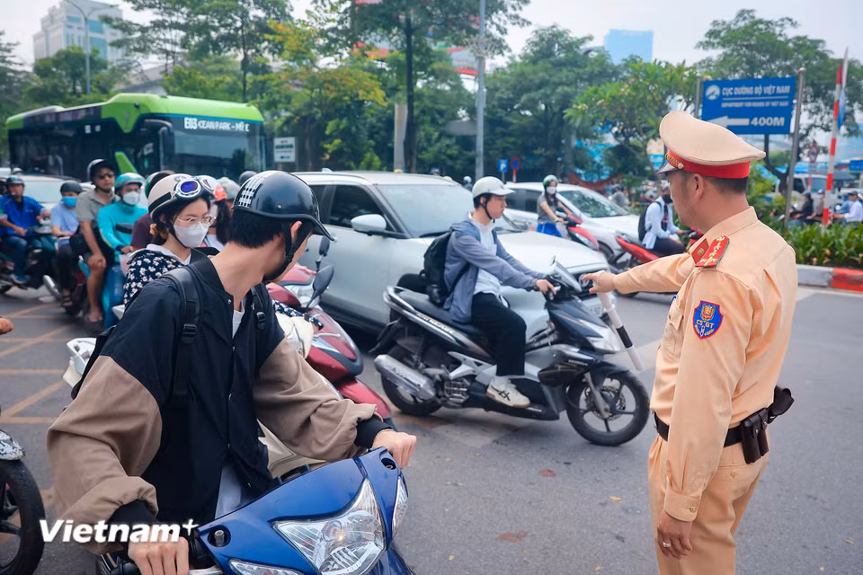 Cùng với việc điều tiết giao thông, Phòng cảnh sát Giao thông Công an Thành phố Hà Nội thường xuyên tuyên truyền về các hành vi như dừng đỗ sai quy định, sai vạch kẻ đường mà nhiều người dân vì di chuyển theo thói quen hay mắc phải. (Ảnh: Hoài Nam/Vietnam+)