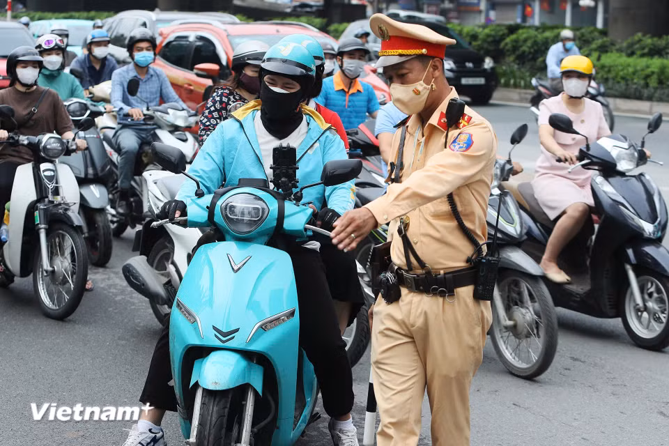 Tổ công tác của Đội Cảnh sát giao thông đường bộ số 7 (Phòng Cảnh sát giao thông Công an Thành phố Hà Nội) đã ghi hình kết hợp xử phạt trong sáng 5/6 20 trường hợp, trong đó có 15 trường hợp xử lý trực tiếp, 5 trường hợp phạt nguội, đa phần là xe ôm công nghệ. (Ảnh: Hoài Nam/Vietnam+)