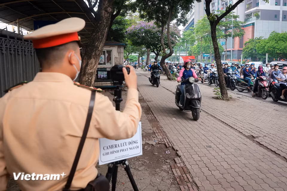 Lực lượng Cảnh sát giao thông đồng loạt ra quân kiểm tra, xử lý tại nhiều khu vực trọng điểm, tập trung vào các lỗi như vượt đèn đỏ, đi ngược chiều, không đội mũ bảo hiểm, điều khiển xe lên vỉa hè, chở hàng hóa cồng kềnh và che biển kiểm soát. (Ảnh: Hoài Nam/Vietnam+)