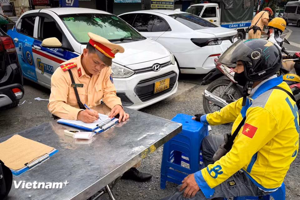 Cùng thời điểm, Tổ công tác của Đội Cảnh sát giao thông đường bộ số 3 (Phòng Cảnh sát giao thông Công an Thành phố Hà Nội) lập chốt xử lý vi phạm Giảng Võ-Cát Linh và Phạm Ngọc Thạch-Nguyễn Ngọc Doãn đã ghi nhận 22 trường hợp vi phạm các lỗi, trong đó có đến 12 trường hợp xe ôm công nghệ. (Ảnh: Hoài Nam/Vietnam+)