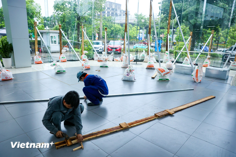 Dọc đường Phạm Văn Đồng, các showroom ôtô cũng đang tất bật gia cố lại phần cửa kính vốn chịu lực kém. (Ảnh: Hoài Nam/Vietnam+)