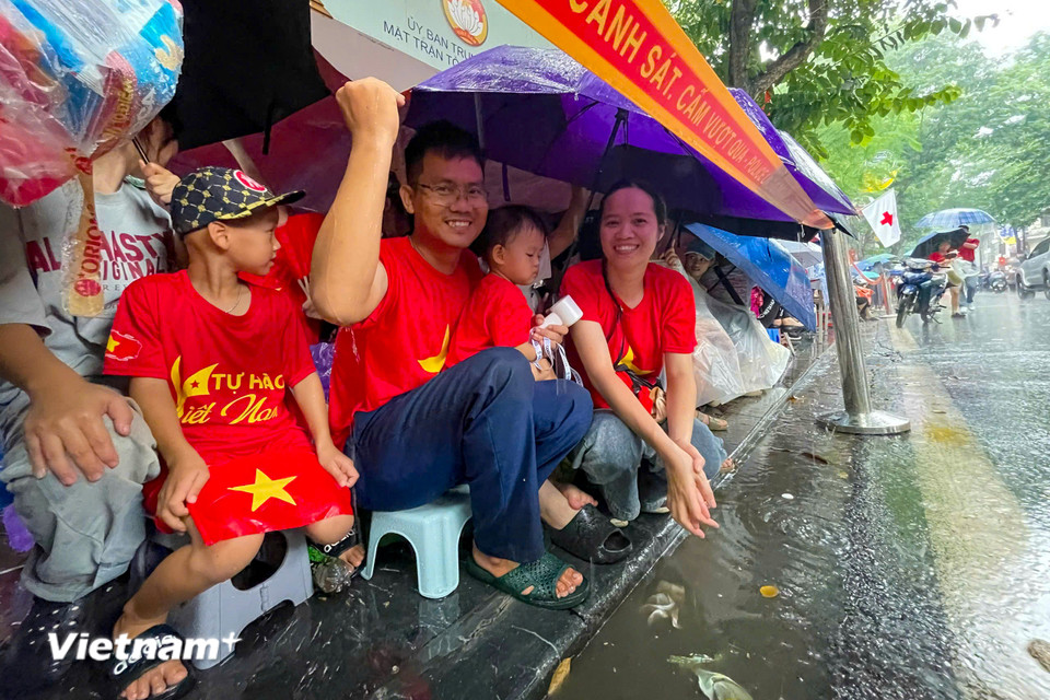 Trời mưa lớn nhưng người dân vẫn hào hứng đón chờ các đoàn diễu binh diễu hành đi qua trước 1 ngày. (Ảnh: Hoài Nam/Vietnam+)