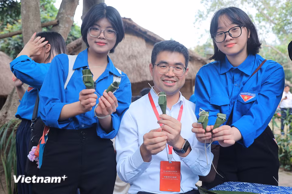 Đoàn thanh niên Trung Quốc hào hứng trải nghiệm làm bánh của người Xơ Đăng. (Ảnh: Hoài Nam/Vietnam+)