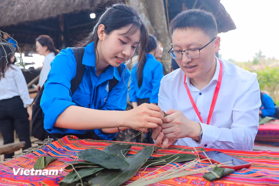Thanh niên Việt Nam làm bánh cùng đại biểu Đoàn thanh niên cộng sản Trung Quốc. (Ảnh: Hoài Nam/Vietnam+)