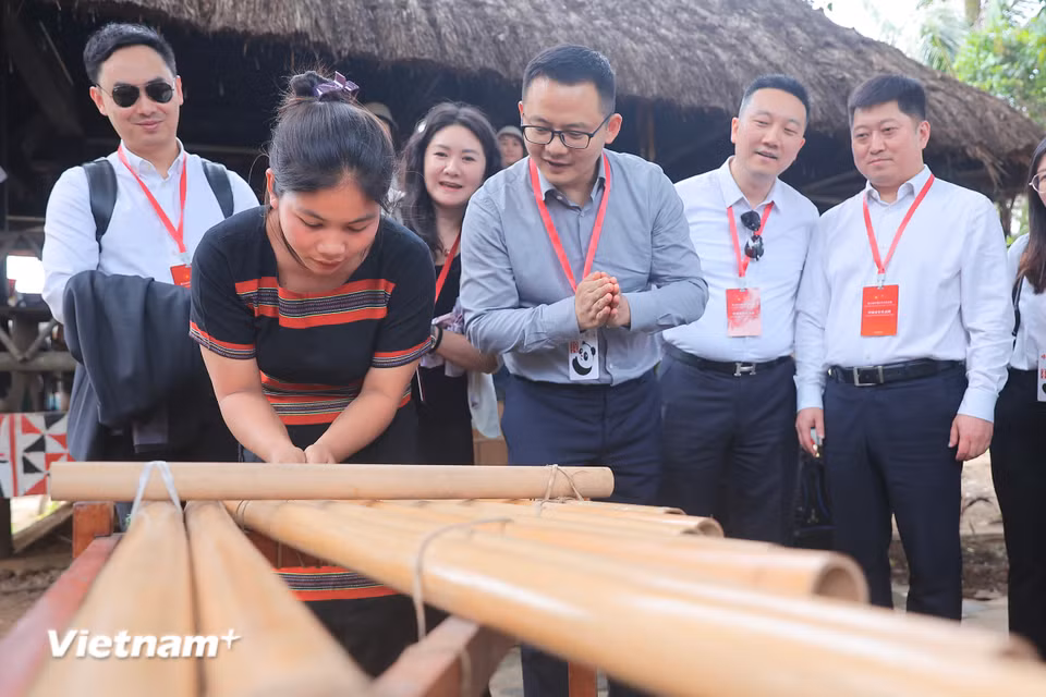 Thanh niên Trung Quốc tìm hiểu về cách sử dụng đàn K'lông pút của người Xơ Đăng. Đây là nhạc cụ của một số dân tộc ở Tây Nguyên, cách sử dụng K'lông pút khá lạ so với những nhạc cụ khác. (Ảnh: Hoài Nam/Vietnam+)