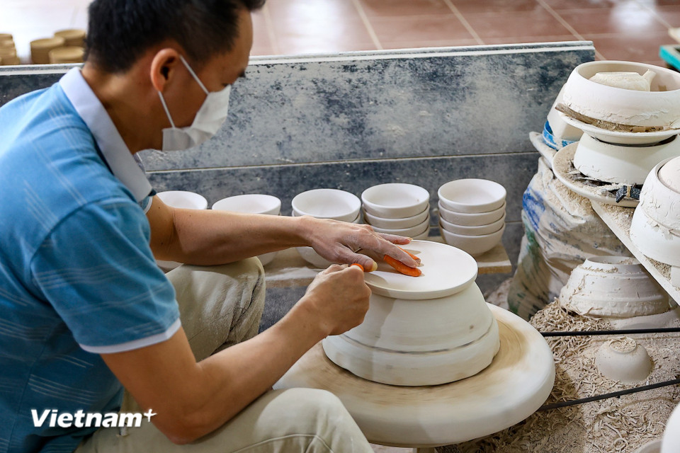 Tại cơ sở sản xuất gốm Tân Long, những người thợ đang tất bật mỗi người một công đoạn sản xuất gốm vụ Tết. (Ảnh: Hoài Nam/Vietnam+)
