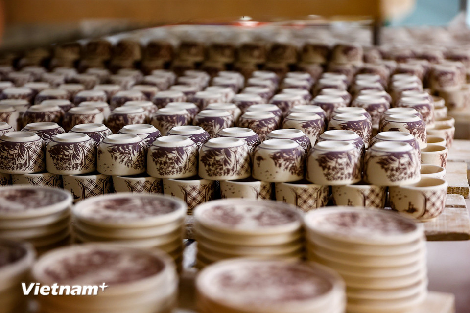 Người thợ chỉ cần quét một lớp nước mỏng sẽ cho ra những họa tiết bắt mắt mà vẫn giữ được ‘hồn’ sau khi nung ra thành phẩm. (Ảnh: Hoài Nam/Vietnam+)