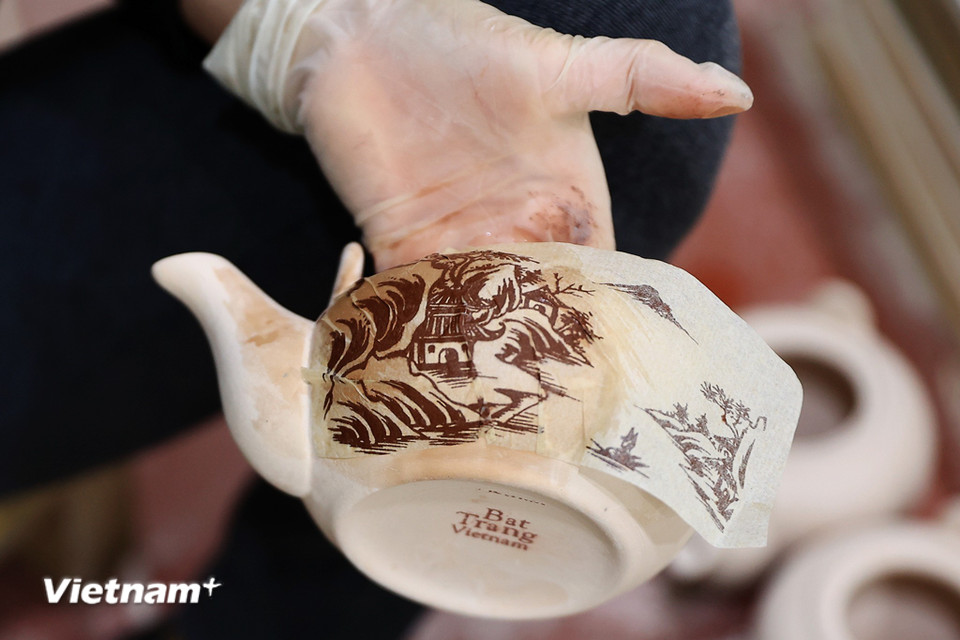Ngoài những sản phẩm được vẽ tay, từ nhiều năm trở lại đây để sản xuất được hiệu quả hơn, một số xưởng gốm đã sử dụng các họa tiết in lên giấy và dán lên sản phẩm thô trước khi nung. (Ảnh: Hoài Nam/Vietnam+)