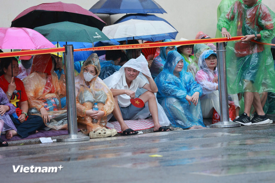 Người dân đội mưa đón chờ màn diễu binh, diễu hành. (Ảnh: Hoài Nam/Vietnam+)