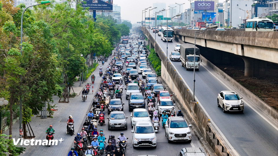 Đường Khuất Duy Tiến qua công viên Thanh Xuân xảy ra ùn nhẹ, một số xe máy bất chấp leo lên vỉa hè để di chuyển. (Ảnh: Hoài Nam/Vietnam+)