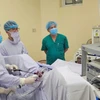 Các bác sỹ thực hiện ca phẫu thuật nội soi cho bệnh nhân. (Ảnh: PV/Vietnam+)