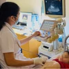 Bác sỹ siêu âm, kiểm tra cho bệnh nhân. (Ảnh: PV/Vietnam+)