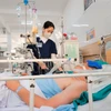 Nhân viên y tế chăm sóc cho bệnh nhân. (Ảnh: Minh Quyết/TTXVN)