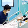 Bác sỹ theo dõi sức khỏe cho bệnh nhân tại Bệnh viện Bệnh Nhiệt đới Trung ương. (Ảnh: PV/Vietnam+)