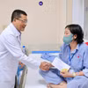 Lãnh đạo Bệnh viện K trao quà hỗ trợ cho bệnh nhân ung thư. (Ảnh: PV/Vietnam+)