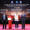 Ban Tổ chức trao chứng nhận và hoa cho các tác giả đoạt giải. (Ảnh: PV/Vietnam+)