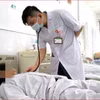 Bác sỹ theo dõi tình trạng cho bệnh nhân. (Ảnh: PV/Vietnam+)