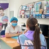 Nhân viên y tế tư vấn về bệnh HIV cho người dân. (Ảnh: T.G/Vietnam+)