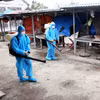 Cán bộ Trung tâm y tế phun tiêu độc, khử trùng. (Ảnh: TTXVN)