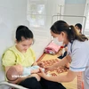 Nhân viên y tế theo dõi sức khỏe cho trẻ em tại Trạm y tế. (Ảnh: T.G/Vietnam+)