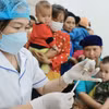 Người dân đưa trẻ đến tiêm chủng. (Ảnh: Minh Quyết/TTXVN)