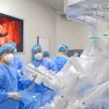 Các bác sỹ Bệnh viện K thực hiện một ca phẫu thuật bằng robot. (Ảnh: PV/Vietnam+)