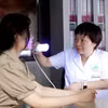 Phó giáo sư Đỗ Thị Thu Hiền khám cho bệnh nhân bị bệnh bạch biến. (Ảnh: PV/Vietnam+)