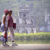 Du khách nước ngoài đi dạo bên hồ Hoàn Kiếm. (Ảnh: Tuấn Đức/TTXVN)