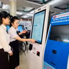 Nhân viên y tế hướng dẫn người dân tại máy đăng ký khám bệnh tự động ở Bệnh viện Đa khoa tỉnh Quảng Ninh. (Ảnh: T.G/Vietnam+)