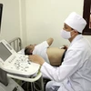 Bác sỹ khám bệnh, siêu âm cho người dân. (Ảnh: TTXVN/Vietnam+)