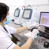 Chuyển đổi số được đẩy mạnh trong ngành y tế. Kỹ thuật viên xét nghiệm quét mã và nhập dữ liệu mẫu máu vào hệ thống, bảo đảm quản lý chính xác. (Ảnh: TTXVN)