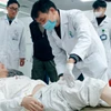 Các bác sỹ Bệnh viện Hữu nghị Việt Đức kiểm tra tình trạng cho các bệnh nhân. (Ảnh: PV/Vietnam+)