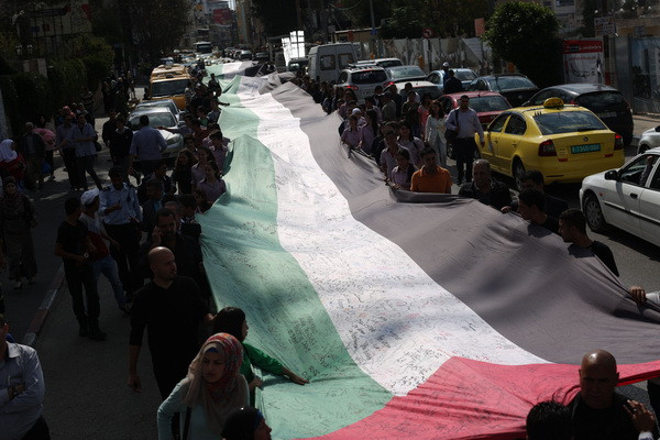 Người dân hy vọng lá quốc kỳ sẽ lập kỷ lục thế giới Guinness cho danh hiệu "lá cờ Palestine lớn nhất" (Ảnh: THX/TTXVN) Palestine: Quốc kỳ 25.000 chữ ký biểu trưng tinh thần dân tộc ảnh 2