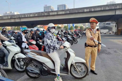 Một trường hợp vi phạm lỗi không chấp hành đèn tín hiệu giao thông bị lực lượng cán bộ, chiến sỹ đội CSGT số 7 dừng xe, kiểm tra và xử lý. (Ảnh: Phạm Kiên/TTXVN)