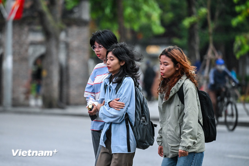 Những vị khách du lịch co ro trong trời lạnh vào sáng sớm ở Thủ đô. (Ảnh: Minh Sơn/Vietnam+)