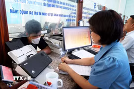 Cán bộ tại bộ phận một cửa hành chính công của UBND huyện Bù Đăng phục vụ người dân. (Ảnh: Hồng Đạt/TTXVN)