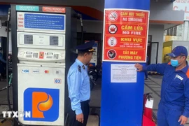 Lực lượng quản lý thị trường thành phố Đà Nẵng triển khai dán thông báo số điện thoại đường dây nóng, tại các cửa hàng xăng, dầu. (Ảnh: Trần Tĩnh/TTXVN)