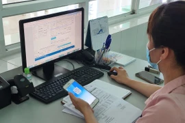 Luật Bảo hiểm xã hội quy định người lao động đóng vào quỹ bảo hiểm xã hội 10,5% tiền lương tháng làm căn cứ đóng bảo hiểm xã hội và người sử dụng lao động đóng 21,5%. (Ảnh: PV/Vietnam+) 