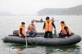 Lực lượng chức năng tìm kiếm các nạn nhân vụ chìm tàu khách tại hồ Thác Bà, Lào Cai ngày 22/2. (Ảnh: Đinh Thùy/TTXVN)