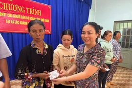 Tặng thẻ bảo hiểm y tế miễn phí cho hộ cận nghèo, người dân có hoàn cảnh khó khăn. (Ảnh: PV/Vietnam+)